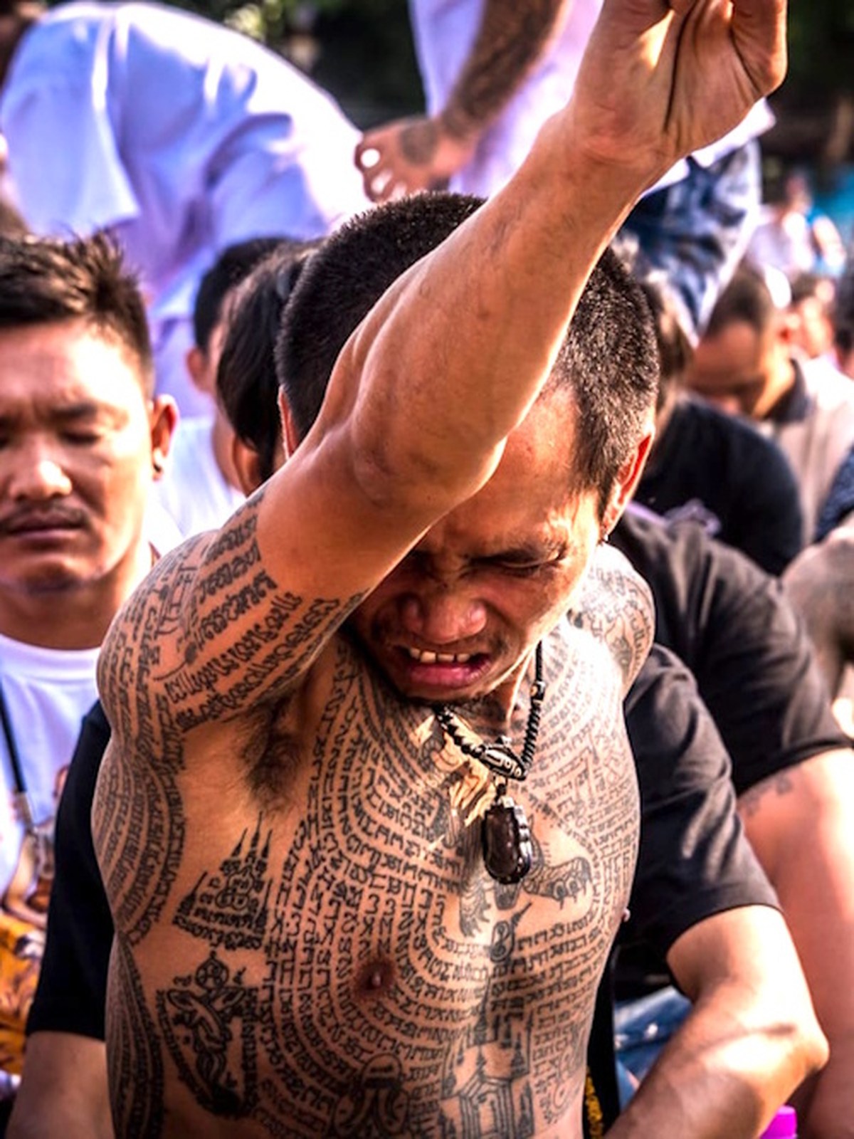 Homme thaï en transe rituelle au temple Wat Bang Phra, célèbre pour les tatouages sacrés Sak Yant à Nakhon Pathom, en Thaïlande.