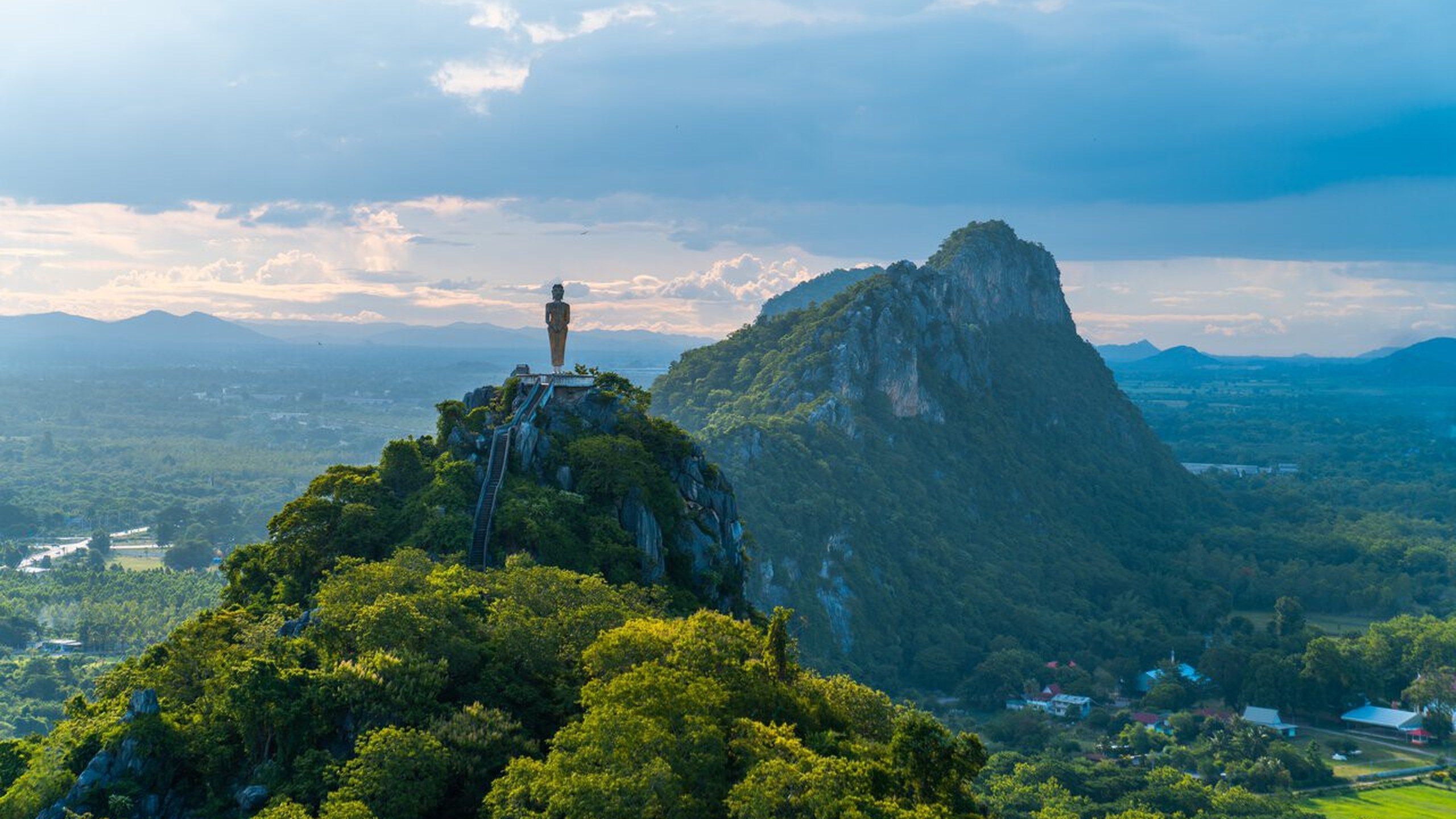 Grand Bouddha debout de Pak Tho, monument bouddhique dominant les collines verdoyantes de Ratchaburi, en Thaïlande.
