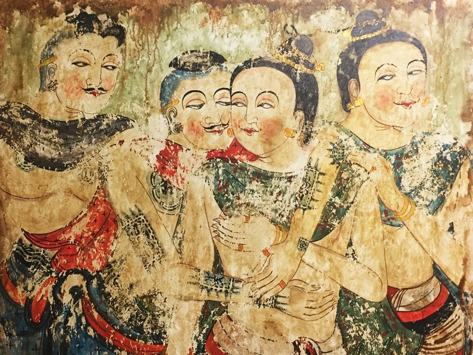 Old, flaking mural showing four figures in northern dress, including an embracing couple whispering to each other.